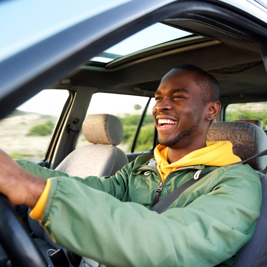 Side portrait of happy african american man driving car